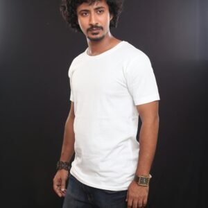 Portrait of a fashionable man in casual attire against a dark background, showcasing modern style.